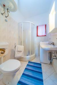 a bathroom with a toilet and a shower and a sink at Apartments Blue Horizon in Cavtat
