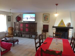 sala de estar con mesa y TV en la pared en Grande maison de vacances au cœur du Perigord Noir nature et confort, en Domme