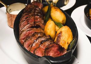 a steak and potatoes in a pan on a table at Dakota Glasgow in Glasgow