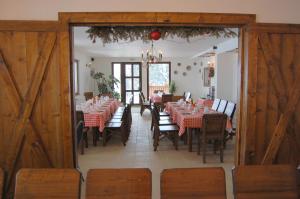 a dining room with tables and chairs with red tablecloths at Cabana Moţilor in Mărişel