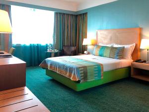 a hotel room with a bed and a desk at Hotel Presidente Luanda in Luanda