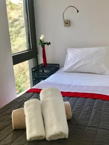 a bedroom with a bed with two towels on it at Red Grey Sea View Villa in Schinias