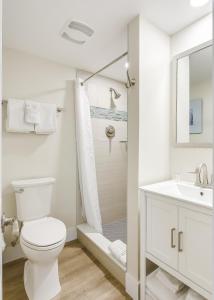 een witte badkamer met een toilet en een douche bij La Jolla Resort in Islamorada