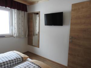 a bedroom with a bed and a television on the wall at Bergschlössl in Goldegg