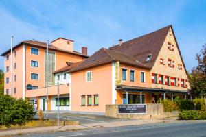 ein großes Gebäude mit einem Schild davor in der Unterkunft Hotel Wilder Mann in Rückersdorf