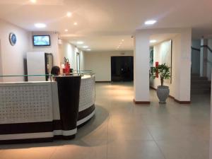 a lobby with a bar in the middle of a building at Pousada Central in Feira de Santana