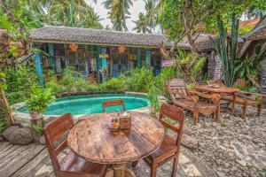 a patio with tables and chairs next to a pool at Santhiku Hotel & SPA in Lovina
