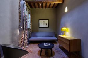 a living room with a blue couch and a table at Palazzetto Rosso - Art Hotel in Siena