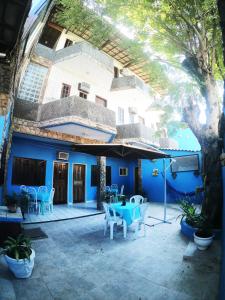 アハイアウ・ド・カボにあるPousada Azul do Marの青い建物で、パティオ(テーブル、椅子付)が備わります。