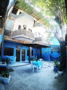 a blue building with a patio with a table and chairs at Pousada Azul do Mar in Arraial do Cabo