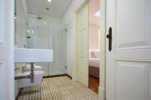 a white bathroom with a sink and a toilet at Downtown Colosseum Apartments in Porto