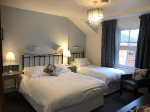 a hotel room with two beds and a window at Newton House Oxford in Oxford