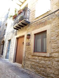 a stone building with a balcony and a window at casa padre Jerone in Gangi
