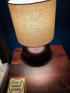 a lamp sitting on top of a wooden table with a sign at Park Lane Guest House in Austin