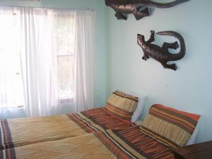 a bedroom with a bed with a dinosaur skull on the wall at 57 Pelican Street in St Lucia