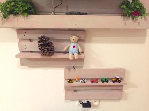 a stuffed teddy bear sitting on a wooden shelf at Dvojizbový Útulný Apartmán Oščadnica in Oščadnica