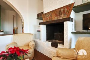 a living room with two chairs and a fireplace at Villa Solelago Exclusive in Lonato