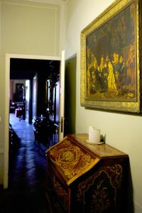 a room with a painting on the wall and a table at Al Tuscany B&B in Lucca