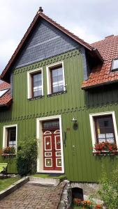 NeuwerkにあるDas Grüne Haus am Gramsegrundの赤いドアと窓のある緑の家