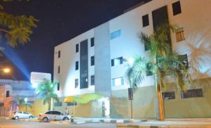 a large building with palm trees in front of it at Pousada Central in Feira de Santana