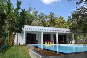 a villa with a swimming pool in front of a house at Muthu Nila villa- Mirissa in Mirissa
