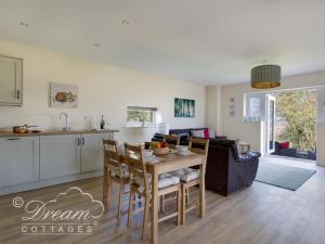een keuken en een woonkamer met een tafel en stoelen bij Markham Cottage in Weymouth