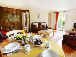 una sala de estar con una mesa con comida. en Sixpenny Cottage, en Upwey