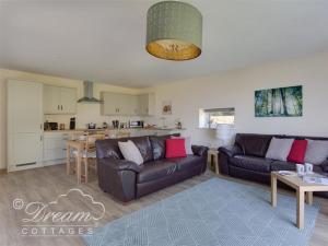 un soggiorno con divano e una cucina di Markham Cottage a Weymouth