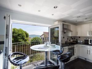 a kitchen with a table and chairs on a balcony at Bowleaze View in Weymouth