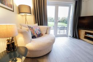 a living room with a chair and a television at Gwelfor in Cemaes Bay +24 photos