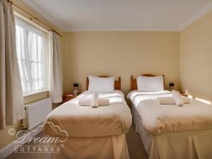 2 camas individuais num quarto com uma janela em Bridge Apartment em Weymouth