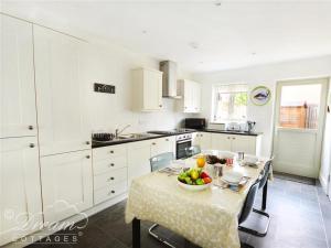 una cocina con una mesa con un bol de fruta. en Olympic Cottage en Portland