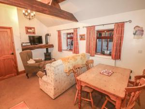 a living room with a couch and a table at Piggery Place in Buxton