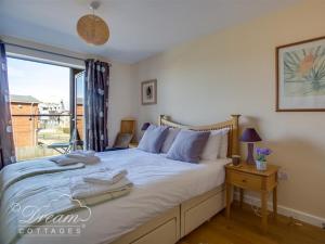 een slaapkamer met een groot bed en een raam bij Harbour View Apartment in West Bay