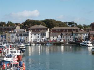 a group of boats docked in a harbor with houses at Buccaneer Cottage in Weymouth