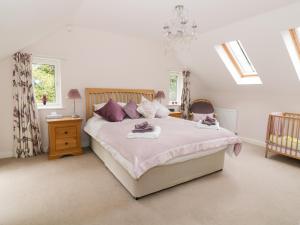 a bedroom with a large bed with purple pillows at Cherry Tree Cottage in Norwich