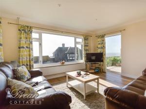 a living room with a couch and a table and a tv at Seacliff in West Bay