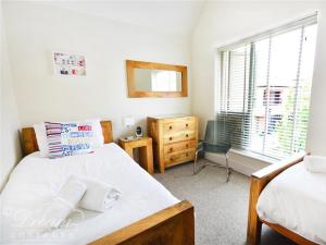 En eller flere senge i et værelse på Olympic Cottage