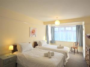 ein Hotelzimmer mit 2 Betten und einem Fenster in der Unterkunft Rainbow's End in Weymouth