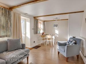 a living room with a couch and a table at Ammonite Cottage in Portland
