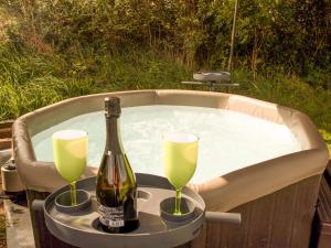 eine Flasche Champagner und zwei Gläser in einem Whirlpool in der Unterkunft Bramble Cottage in Haverfordwest