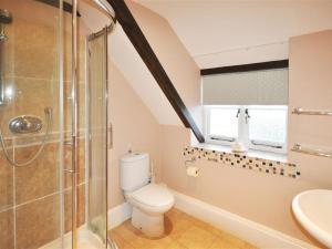 a bathroom with a toilet and a glass shower at Ivy Cottage in West Lulworth