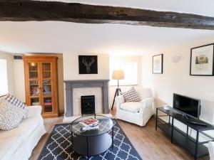 a living room with a white couch and a fireplace at Manor Farm House Cottage in Kettering