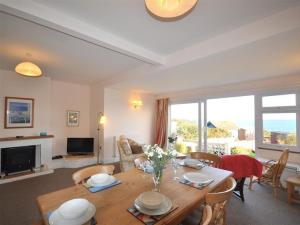 a living room with a wooden table with chairs and a living room at Rainbow's End in Weymouth