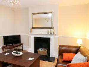 a living room with a couch and a fireplace at Newden Cottage in Whitstable