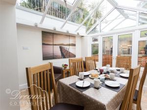 a dining room with a table in a conservatory at Redcliff View Lodge in Weymouth