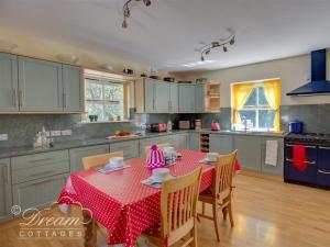 a kitchen with a table with a red table cloth at Harbour View Bungalow in Weymouth