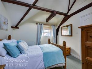 ein Schlafzimmer mit einem Bett und einer Holzdecke in der Unterkunft Rupert Cottage in Weymouth