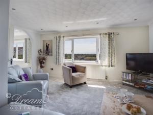 a living room with a couch and a tv at Bowleaze View in Weymouth