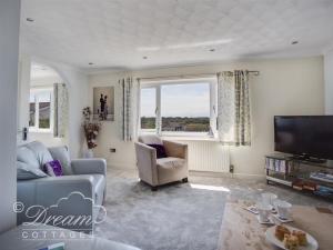 ein Wohnzimmer mit Sofa und Fernseher in der Unterkunft Bowleaze View in Weymouth